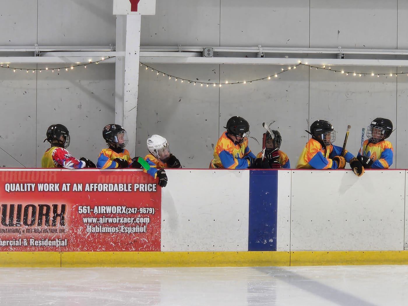 Players at the boards in custom team jerseys
