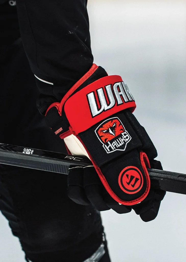 Warrior hockey glove with embroidered Hawks team crest on the cuff