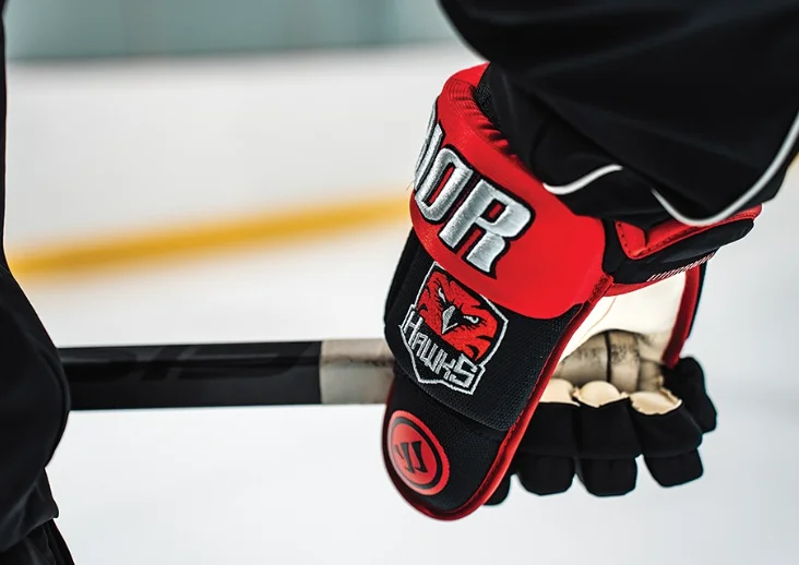 Custom team glove with Hawks crest held at the rink
